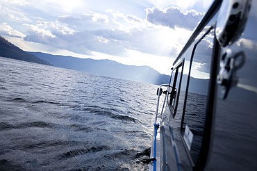 <p>Morning sunlight breaks through the clouds over Lake Pend Orielle as the Boats for Heroes 31-foot aluminum fishing boat makes its way to a fishing hole on July 22, 2016. Boats for Heroes, the non-profit founded by Vietnam veteran Keith Mathews and his wife Cathy, takes veterans and their families out on free fishing trips in Washington and Idaho.</p>