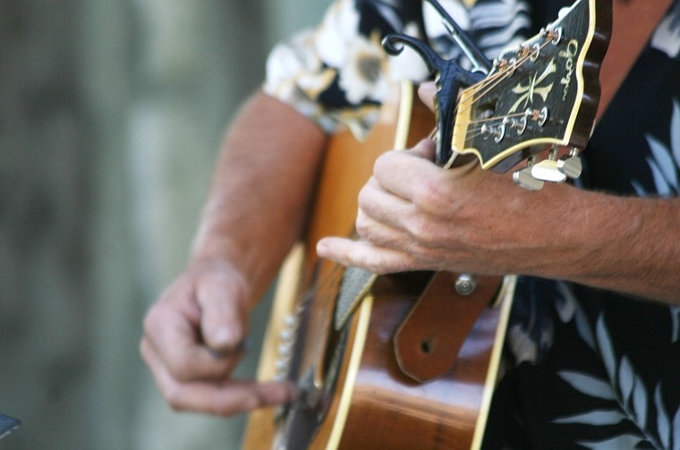 Stauffer plucks the guitar.