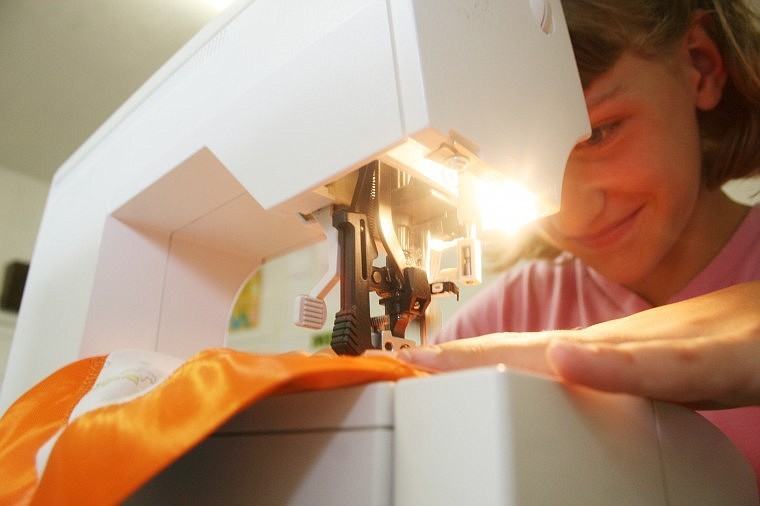 Nine-year-old Madeline Snell, from the Thompson Falls Mountaineers, works the sewing machine at the Plains United Methodist Church on Thursday. Madeline was making a receiving blanket used for newborn children.