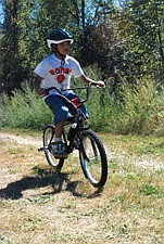 Sage Chieftstick, of Ronan, crosses the finish line during the finale of the BMX bike race to take home first place and a brand new orange bike.