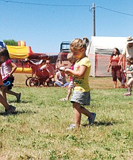 Three-year-old Genesis Holdaway, of St. Ignatius, focuses on the finish line while competing in the egg race.