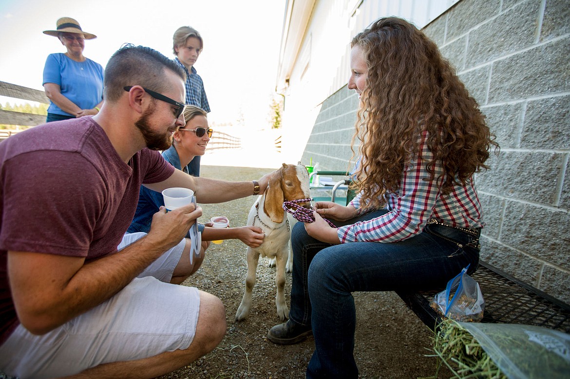 &lt;p&gt;Ryan Bones and Cassidy Miller of Coeur d'Alene pet Woody the goat on Thursday at the Rocking R Ranch's third-annual 4H fundraiser as Woody's owner, Baylee Crupper, talks about what it was like to raise him as part of the 4H program.&lt;/p&gt;