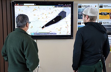 <p>As firefighters, park rangers and first responders gather in the St. Mary Visitor Center for an interagency meeting responders review the map of the fire and the smoke (in darkening shades of black) being created by the Reynolds Creek Fire on Wednesday, July 22, in East Glacier. (Brenda Ahearn/Daily Inter Lake)</p>