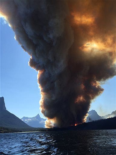 <p><strong>Smoke from</strong> the Reynolds Creek Fire boils above St. Mary Lake in Glacier National Park on July 21. State Rep. Jenny Eck, who was hosting a delegation from Australia on a tour of the park, took this photo of the fast-moving wildfire. The flames torched a car and a historic cabin and forced visitors to abandon their vehicles on the parks most popular roadway while officials evacuated hotels, campgrounds, homes and trails. (Jenny Eck via AP)</p>