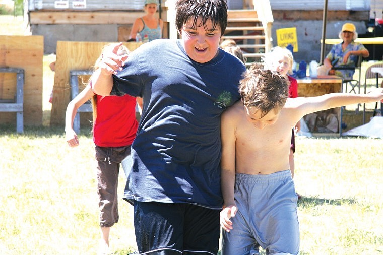 Dominic and Cameron Rosatti, of Big Arm, try to keep it together during the three-legged race at Saturday's 100-year celebration in Big Arm.