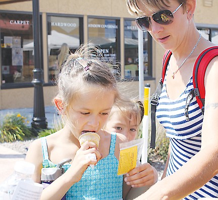 &lt;p&gt;Emily Matt looks at an angel keychain while taking a lick of her ice cream cone. Fellowship Baptist Church was giving the trinkets away during the festival.&lt;/p&gt;