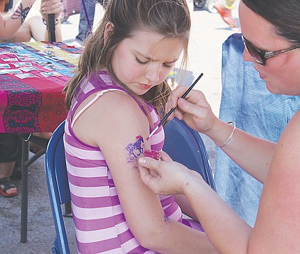 &lt;p&gt;Marie Johnson applies a glitter tatoo to Jillian Griffin's arm as part of a fundraiser for Mission Valley Christian Academy.&lt;/p&gt;