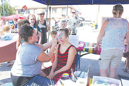 &lt;p&gt;Sheree Vainio paints Alex Loughlin's (of Polson) face. The face painting and glitter tattoo booth was one of four that were fundraisers for Mission Valley Christian Academy.&lt;/p&gt;