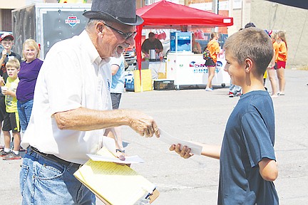 &lt;p&gt;Ken Avison, the comandeer of the pit spit contest, hands Bladen Flynt his award for getting first place in the children's portion of the competition. Flynt is visiting family in Polson from York Nebraska. He spit his cherry pit 36 feet, 4 inches.&lt;/p&gt;