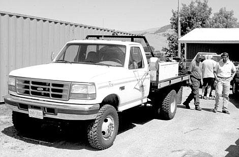 Jamie Doran/Valley Press Cal Minemyer, left, and Ted Meade, right both of the DNRC, look over the new fire engine that the DNRC provided to the Dixon Fire Department.