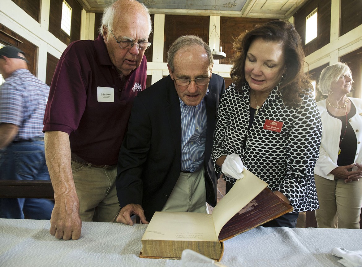 &lt;p&gt;North Idaho State Historical Society Executive Director Janet Gallimore, right, turns pages of the Pacific Railroad Report Volume 12 book very carefully for both U.S. Senator Jim Risch, middle, and North Idaho Museum board member Don Pischner.&lt;/p&gt;