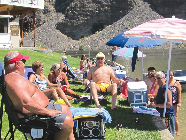 Bill Fisher, white visor, enjoys the classy, grassy beach on
Crescent Bar's east channel, just outside his back door, with
neighbors and friends from across the island.