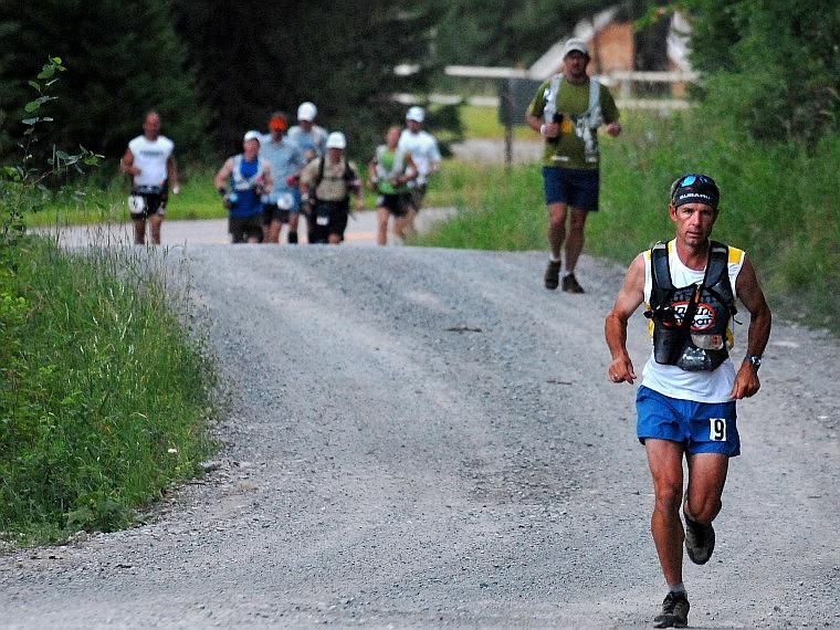 Dan Barger leads the group of runners in the Swan Crest 100 off of Highway 83 onto Lost Creek Road Friday morning. Barger on Saturday morning was the first finisher in a time of 24 hours, 37 minutes for the 100-mile run along the Swan Crest. By midnight, 20 runners had dropped out of the race; 44 runners started the race Friday morning in Swan Lake. The second-place finisher, in a time of 26:24, was Scott Gaiser of Creston (at far left in this photo). Justin Yates placed third in 27:21. For race updates, go to www.swancrest100.com