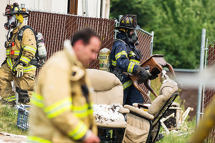 &lt;p&gt;Firefighters with Kootenai County Fire and Rescue work the scene as another firefighter with Northern Lake Fire District carries a piece of furniture from a Post Falls structure fire.&lt;/p&gt;