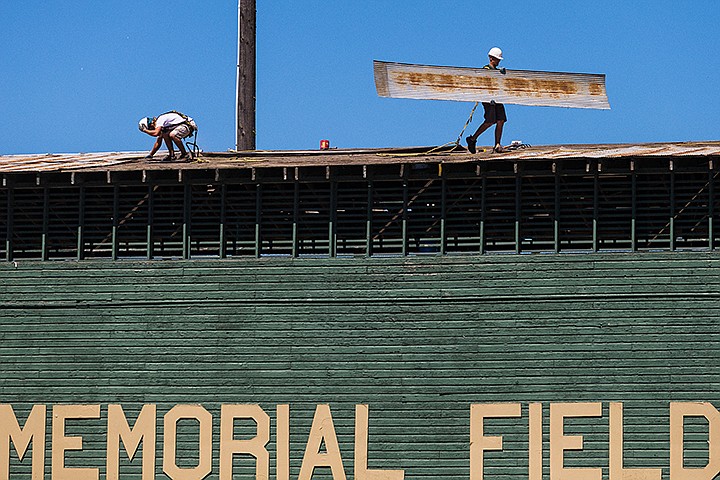 &lt;p&gt;SHAWN GUST/Press&lt;/p&gt;&lt;p&gt;Clayton Orr, tear-off foreman for Halfhide Kline Roofing, works to unfasten roof materials as laborer Jaime Steadman carries a large sheet of metal across the roof of Memorial Field&#146;s stadium Monday in Coeur d&#146;Alene. The $16,000 roof replacement project, which is being done due to normal wear, will be green to match the walls of the building and is scheduled to be completed later this week.&lt;/p&gt;
