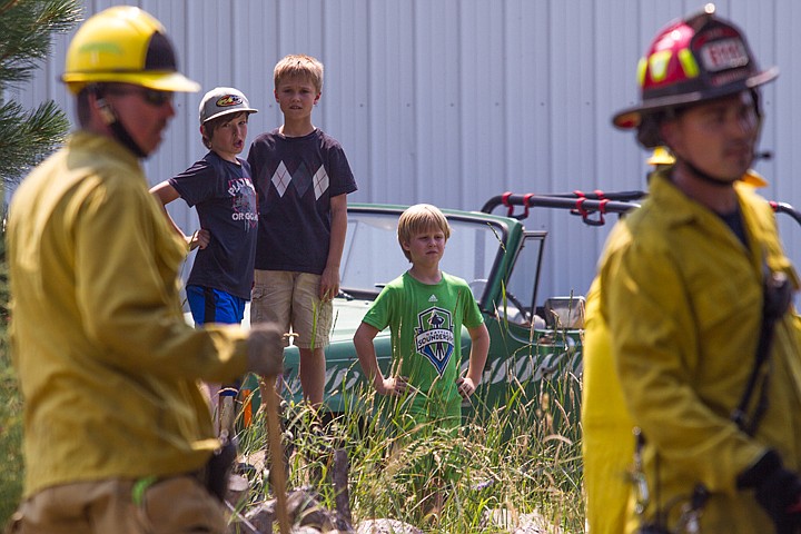 &lt;p&gt;JAKE PARRISH/Press&lt;/p&gt;&lt;p&gt;From left to right, Ricky Rowland, 10, Josh Nelson, 11, and Tyler Nelson, 9, watch firefighters put out a small grass fire behind the Nelson's home on Wednesday on Chase Road in Post Falls. Recent hot and dry weather has elevated Kootenai County's fire risk to high.&lt;/p&gt;