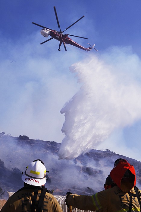 &lt;p&gt;A Los Angeles Fire Department helicopter drops water on a hillside subdivision on the outskirts of Palmdale, Calif., on Friday to help combat wildfires.&lt;/p&gt;