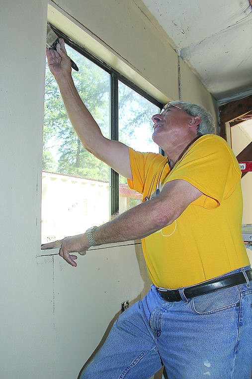 &lt;p&gt;Howard Bakke works on trimming a window with paint.&lt;/p&gt;