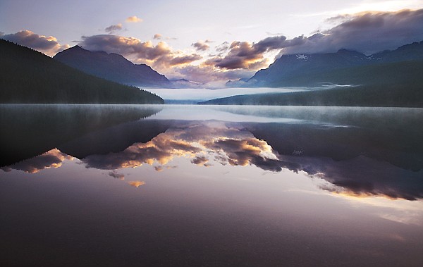 &lt;p&gt;Bowman Lake begins to light up, revealing low clouds and fog,
shortly before sunrise on Thursday in Glacier National Park. The
scenic lake can be reached by traveling up the North Fork Road to
Polebridge and then following a six-mile road to the lake.&lt;/p&gt;