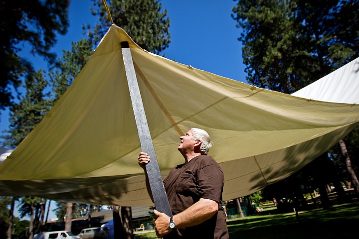 &lt;p&gt;JEROME A. POLLOS/Press David Larsen supports the corner of a large tarp as workers secure the ropes suspending the canopy Thursday in preparation for the 42nd annual Art on the Green event that begins today.&lt;/p&gt;