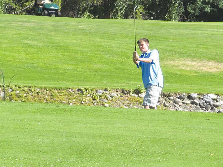 Nikolas Soros, 13, of Everett, went out for a round of golf on
the Crescent Bar Golf Course. Nikolas prepares to chip on. It was a
tough hole for Nikolas, who found the pond to be a nuisance. One of
his shots had to be from water's edge.