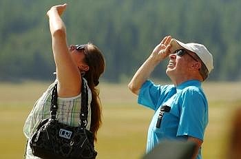 BECKIE LAWLOR and Doug Wendt watch a group of skydivers make their way back to the ground Wednesday afternoon. Nate Chute/Daily Inter Lake