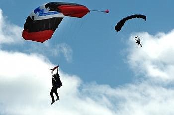 TWO SKYDIVERS parachute past the clouds during the 42nd annual Skydive Lost Prairie Boogie Wednesday afternoon. From tandem, first time jumpers to seasoned skydivers, the event brought people from across the country to the field just north of McGregor Lake. Nate Chute/Daily Inter Lake