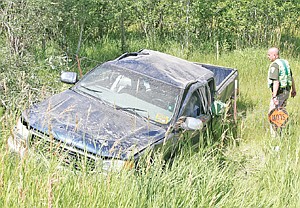 <p>MHP Sgt. Duane Bowers inspects damage to a 2001 GMC pickup with Iowa plates Wednesday afternoon at the 45 mile marker on Hwy 2.</p>