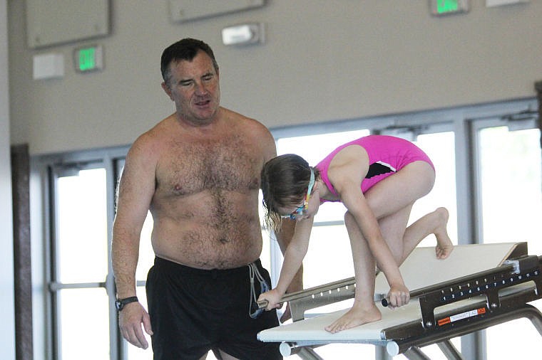 <p>Mark Johnston watches as Isabel Seeley starts off the block on Thursday.</p>