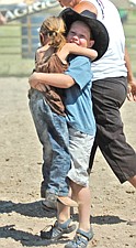 3-year-old Timber Cote, of Ronan, is hugged by her older brother, Carter, after she rode a sheep during Pioneer Days last weekend in Polson.