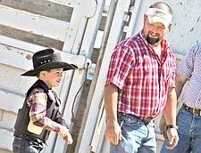 Pat O'Conner, of Arlee, smiles at his 5-year-old son Garrett after he rode sheep during the Pioneer Days rodeo last weekend in Ronan.