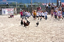 Kids run after chickens during the chicken scramble. If they got ahold of one, they got to keep it.