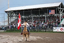 Moriah Gilmore, of Charlo, holds the Canadian flag during the opening ceremonies of the Pioneer Days rodeo last weekend in Ronan.