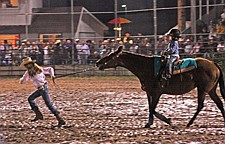 Cheyanne Morrison, of Polson, leads Kianna Hensley, of Charlo around the rodeo arena during the kids barrels event of Pioneer Days last weekend in Polson.