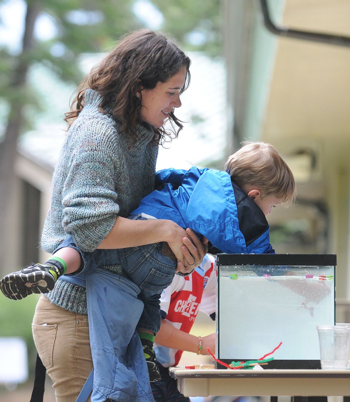 <p>Tricia Youngblood holds her son Bennett as he tries to grab the contraptions people made in the phytoplankton display at the Flathead Lake Biological Station on Wednesday. (Aaric Bryan/Daily Inter Lake)</p>
