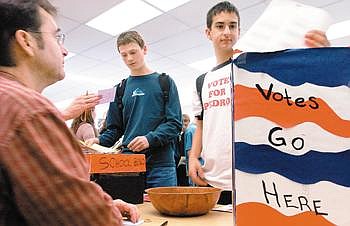 Sporting a &quot;Vote for Pedro&quot; shirt Flathead High School junior Zack Moschetti and his friend sophomore Zac Ford turn in their votes to student teacher Clint Anderson, who was acting as an election moderator at the school's student election Tuesday in Kalispell. Chris Jordan/Daily Inter Lake