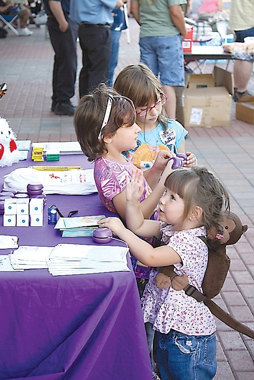 Kids choose from an array of giveaways at the National
Children's Study booth during the Moses Lake Night Out Tuesday. The
event, which was sponsored by the Moses Lake Police Department, was
geared toward enhancing awareness of crime prevention and drew
hundreds of people.