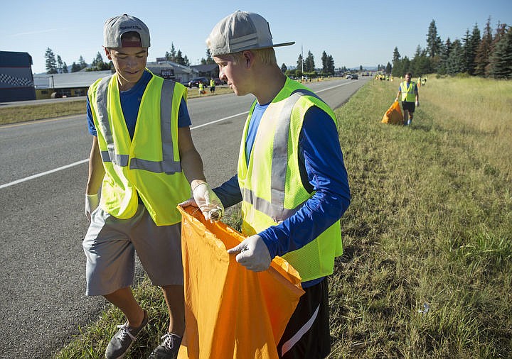 &lt;p&gt;LOREN BENOIT/Press Coeur d'Alene High School football player Chase Dixon, left, places a piece of trash into Jared Harper's bag as they clean up a section of Highway 95 north of Parker Subaru to Sears on Thursday, July 28, 2016. Around 60-80 CHS players, coaches and parents showed up to clean the section of highway they adopted to honor Coeur d'Alene Police Sgt. Greg Moore who was killed last year in the line of duty.&lt;/p&gt;