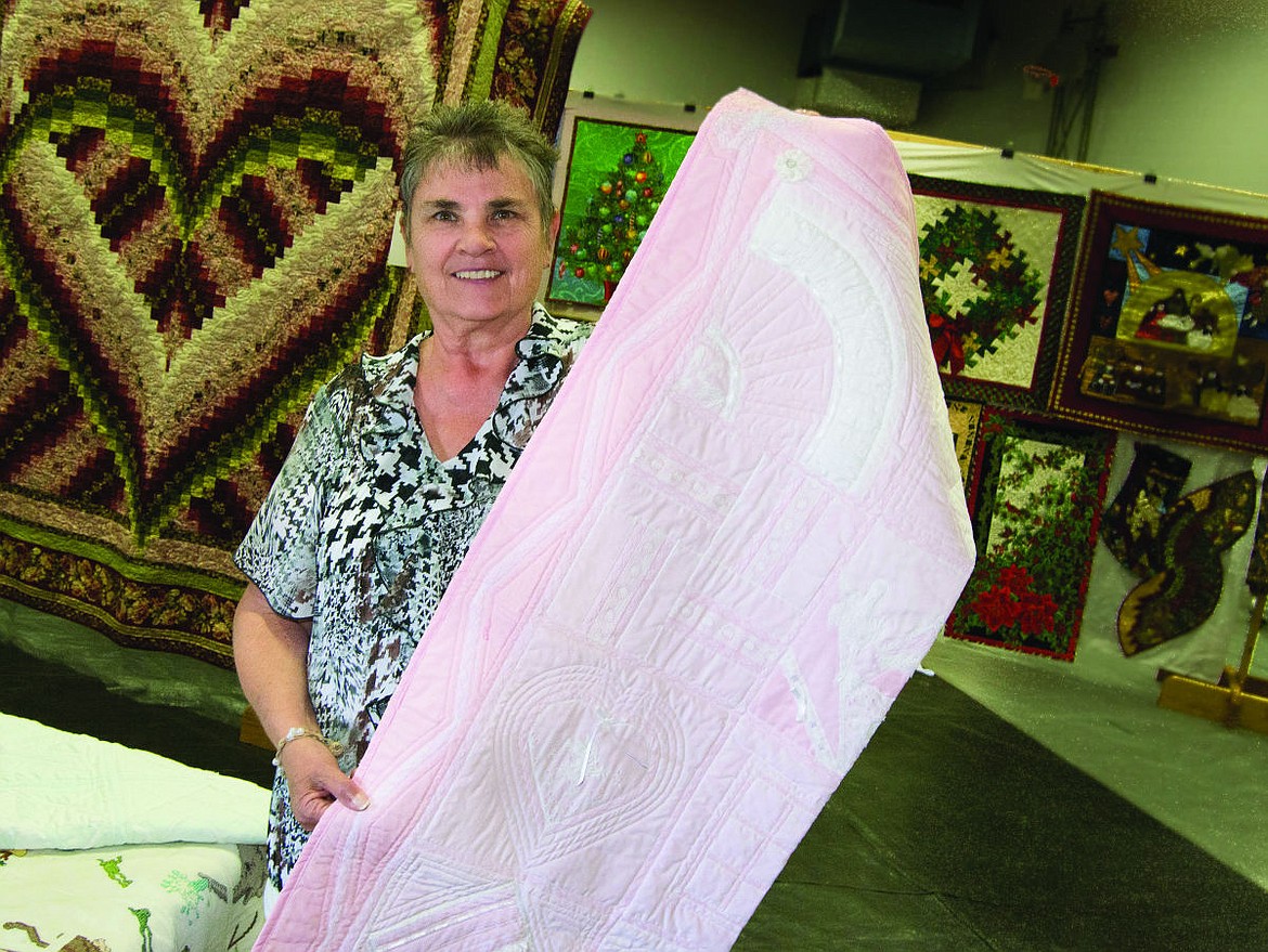 &lt;p&gt;Kay Krantz holds up an heirloom quilt.&lt;/p&gt;