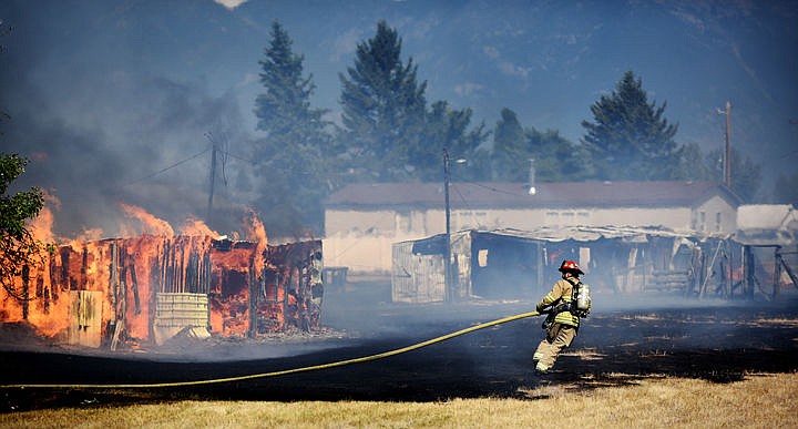 &lt;p&gt;A firefighter battles a fire in an outbuilding south of the main structure fire on Wednesday, August 5, on Mountain View Drive in Evergreen. (Brenda Ahearn/Daily Inter Lake)&lt;/p&gt;
