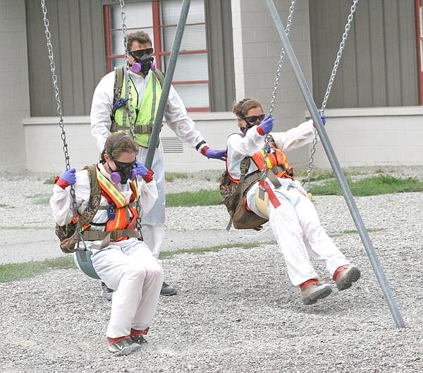 Canda Harbaugh/The Western News ACTIVITY-BASED TESTING AT SCHOOLS: CDM employees imitate the actions of elementary school children Tuesday at Asa Wood&#146;s playground as part of the Environmental Protection Agency&#146;s activity-based sampling. Sampling has begun at both the elementary and high school and will move on to the administration building, middle school and old Plummer building which houses Head Start.