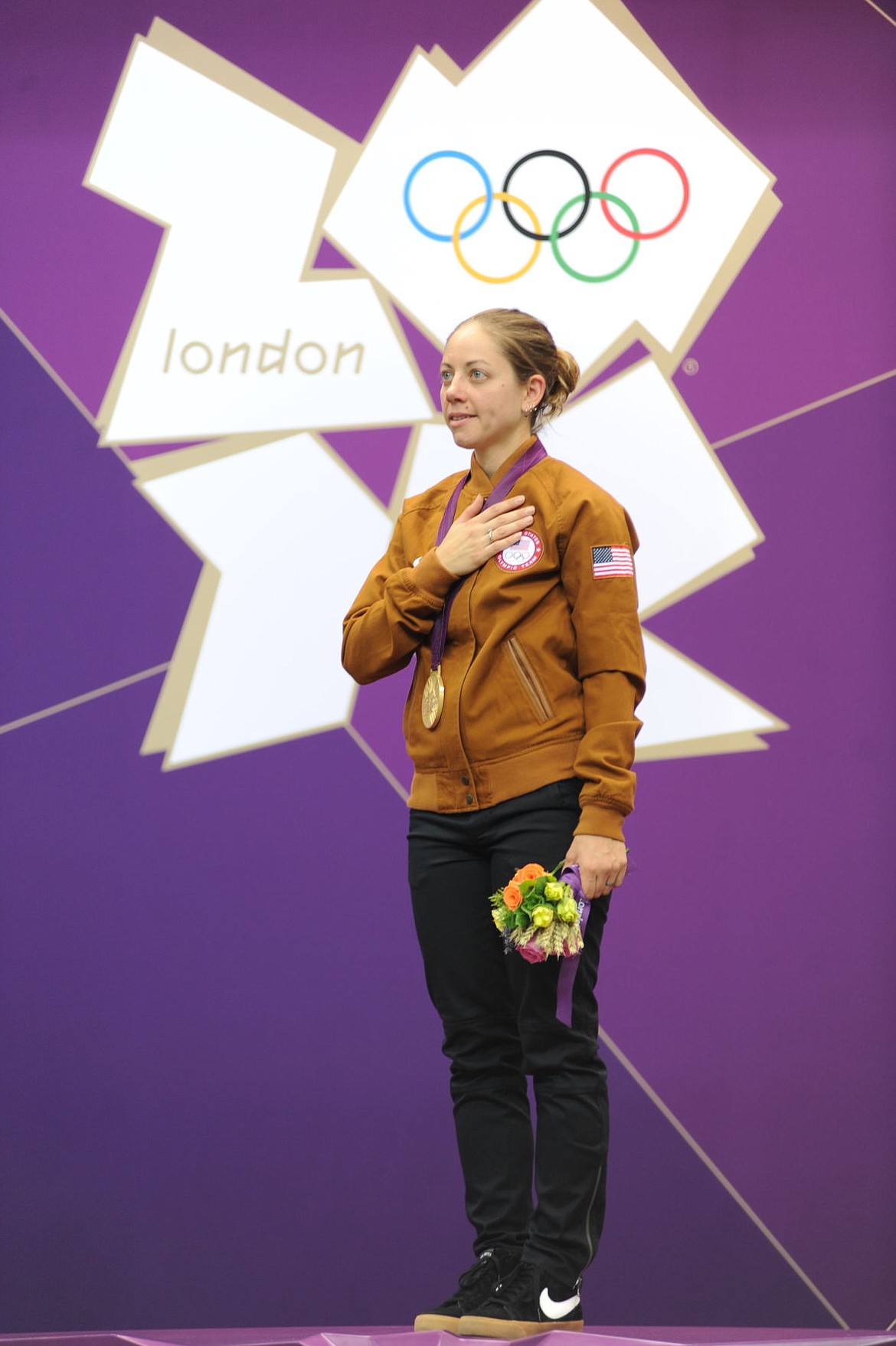 <p>Gold medalist Jamie Corkish listens to the Star Spangled Banner after winning 50-meter three-position rifle shooting at the 2012 Olympic Games in London. Corkish moved to Kalispell with her family in 2013. (Tim Hipps/U.S. Army IMCOM)</p>