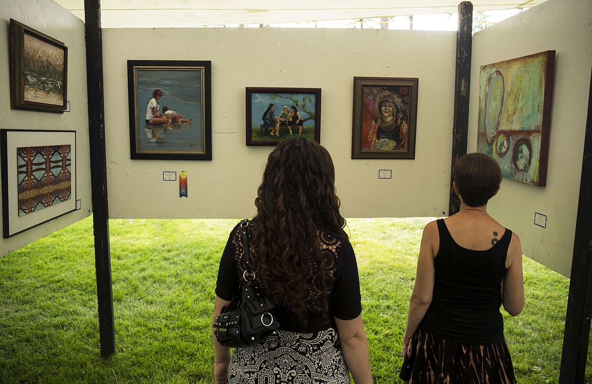 &lt;p&gt;Susan Glasgow, left, and Cindy Walker of Coeur d'Alene view artwork at the juried art show tent, Friday, at Art on the Green.&lt;/p&gt;