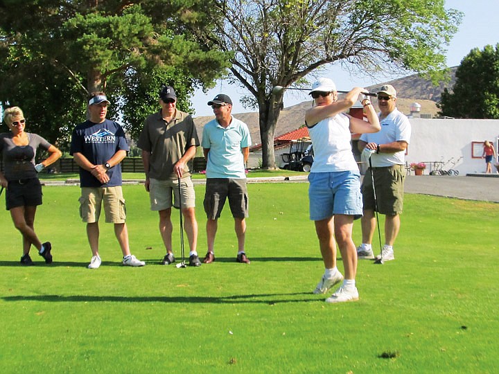 Carol Schultz of Kenmore tees off at Crescent Bar while her husband and four friends wait their turns. The others in the group are John Schultz, Terri and Jeff Teigen of Anatone and Lance David of Federal Way and Allen Oster of Puyallup. They were staying at Crescent Bar to attend the Journey, Lover Boy and Pat Benatar concerts at the Gorge.