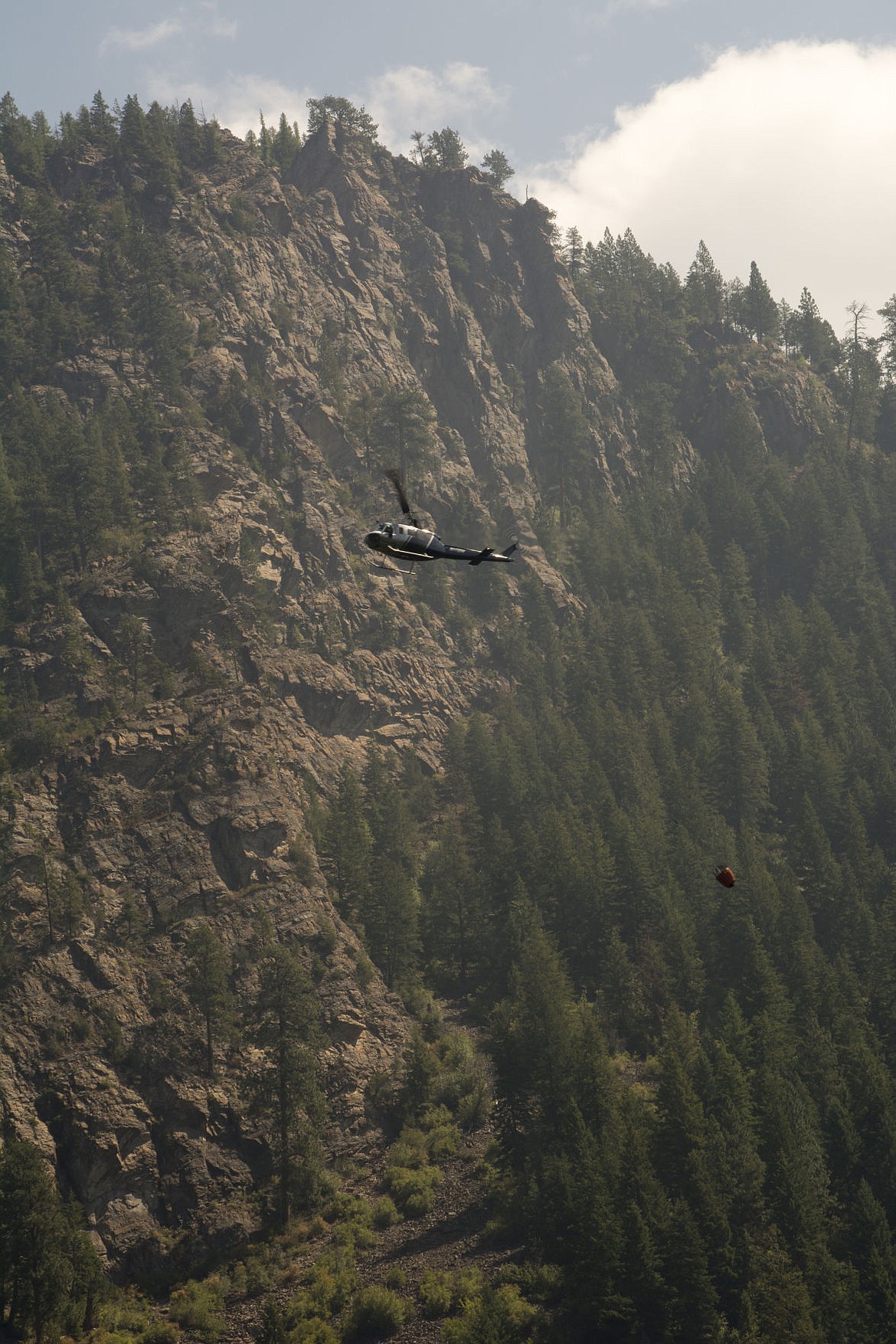 &lt;p&gt;A helicopter performs a bucket drop along ACM road on Thursday. Air support has been continuous throughout the week, as crews battle to contain the Copper King wildfire in Thompson Falls.&lt;/p&gt;