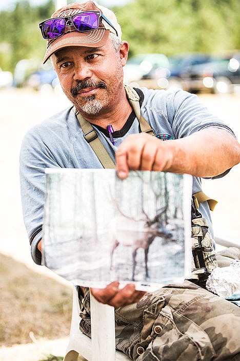 <p>Paul Clock, president of Coeur dAlene Bowmen Inc. takes a break from the Fall Warmup Saturday and shows a photo of a bull elk he recently captured on a camera. Clock mentioned it was like Christmas.</p>