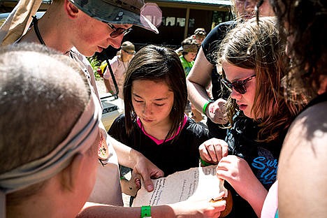 &lt;p&gt;Johnathan Mosmin, left, holds a list of challenges his team must complete in order to win &quot;treasure&quot; as Destiny Hooley, center, looks on at Camp Journey Wednesday at Ross Point Camp in Post Falls.&lt;/p&gt;