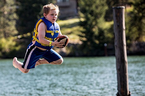 &lt;p&gt;Elijah Michael Foster, 9, sails through the air after jumping off a diving board and catching a football at Camp Journey on Wednesday.&lt;/p&gt;