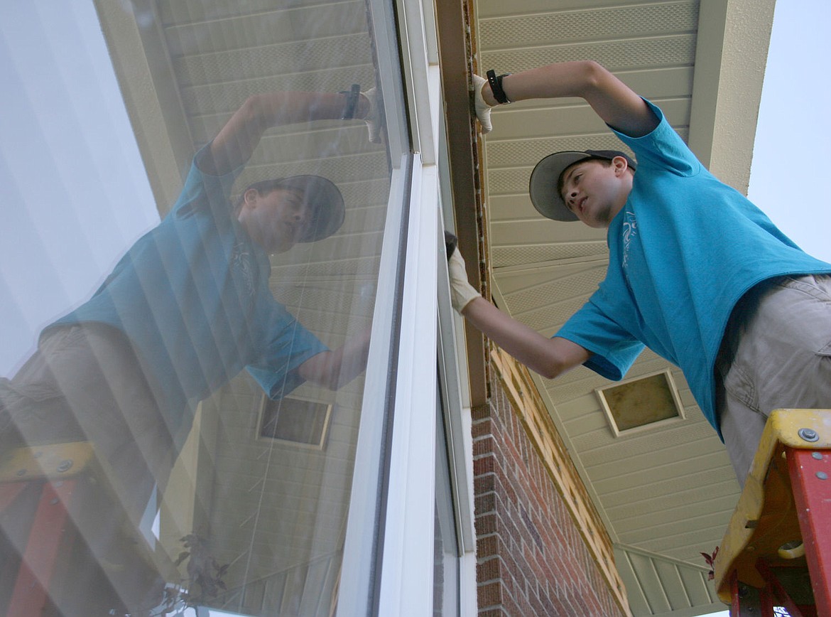 &lt;p&gt;Michael Oandith with the New Day Fellowship from Springdale, Arkansas cleans windows at St. Regis High School on Tuesday, July 29.&lt;/p&gt;