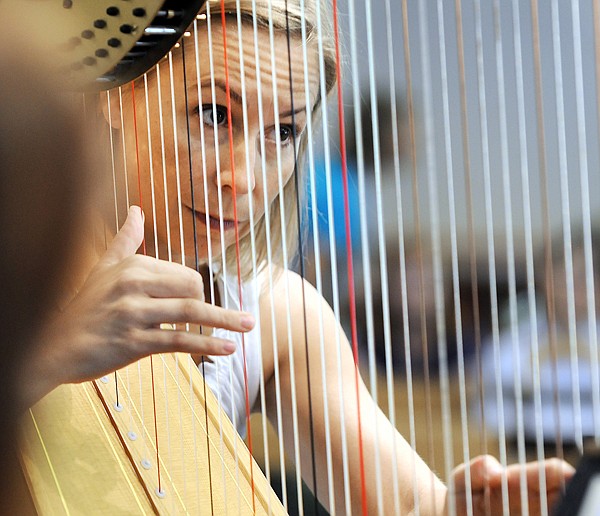 Heidi Krutzen plays the harp as she and Lorna McGhee, on flute, Miriam English Ward on viola, rehearse Debussy's Sonata for Flute, Viola at the open rehearsal on Tuesday at the Four Square Church in Whitefish.